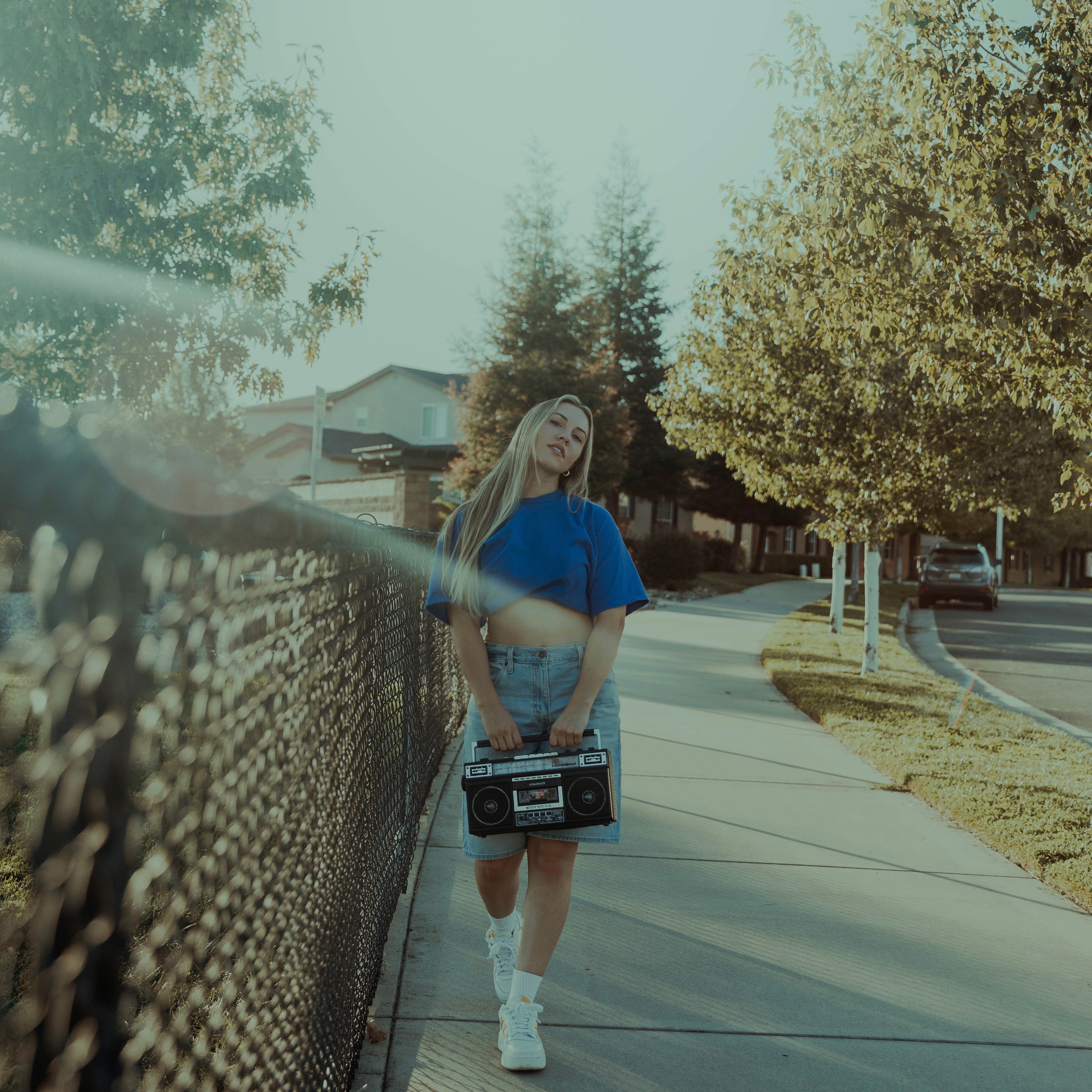Madelynne West standing outdoors holding a vintage boombox